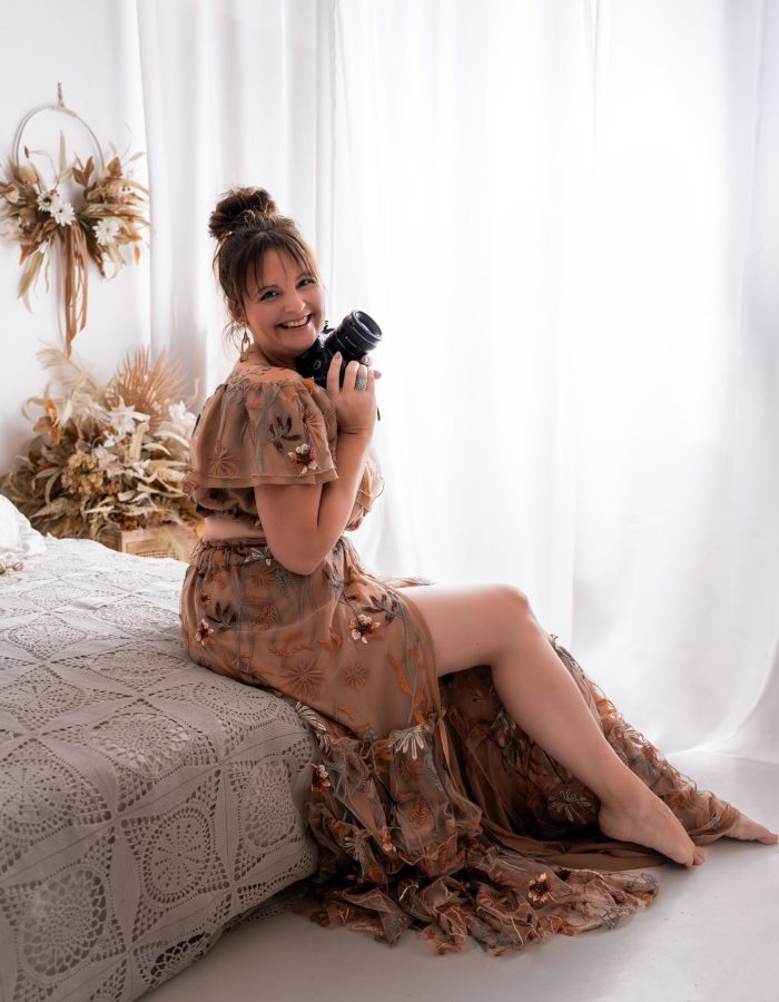 photographe de Normandie avec un appareil photo dans la main dans un studio bohème à Beuzeville